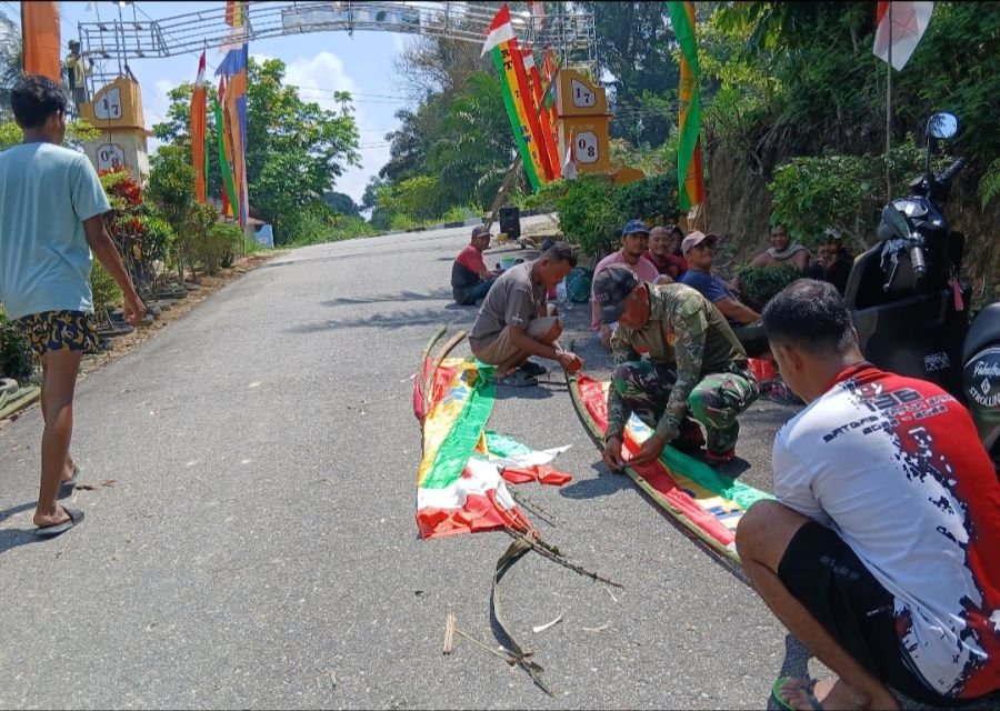 Babinsa Desa Makmur Bersama Warga Gotong Royong Pasang Umbul-Umbul HUT RI ke-81