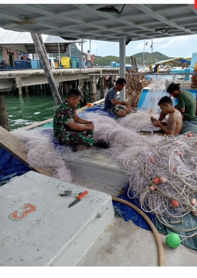 Babinsa kampung hilir turun tangan langsung,bantu perbaiki jaring nelayan binaan  yang rusak.