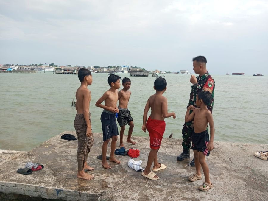 Babinsa kel Kampung Bugis memberikan himbauan kepada anak-anak utk berhati-hati saat bermain di laut