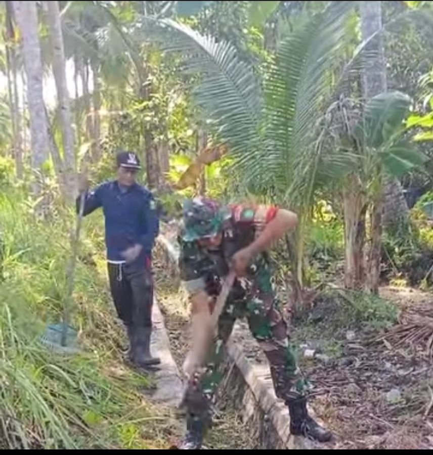 Babinsa Kelanga Turun Langsung Dampingi Warga Bersihkan Drainase Desa