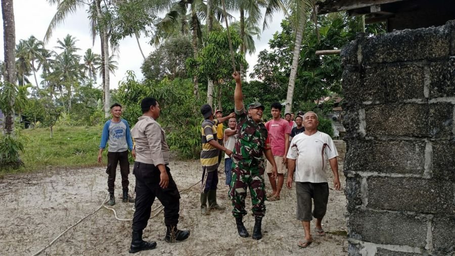 Babinsa Marok Tua dan Warga Tebang Pohon Kelapa yang Ancam Rumah