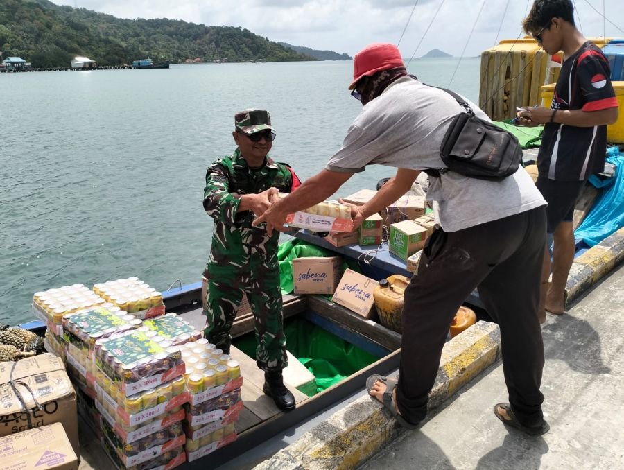 Babinsa koramil 06/serasan sertu Y. Chaniago membantu warga binaan  membongkar sembako dari  pompong