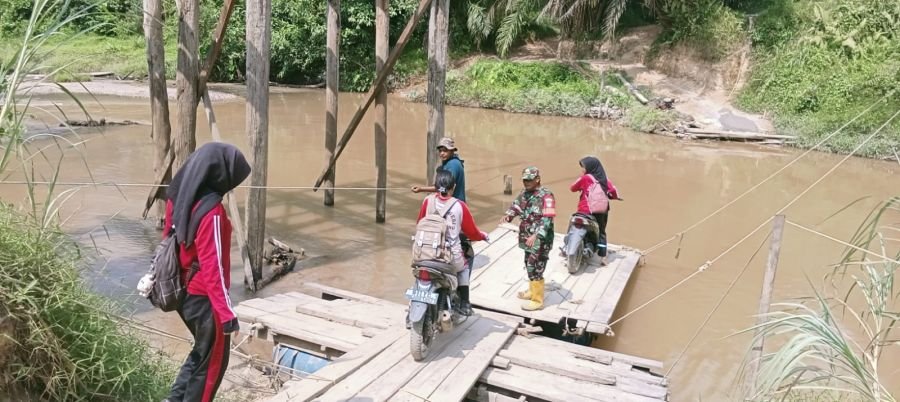 Babinsa Koramil 09/Kemuning Serka Rizal Nst Pantau Penyeberangan Warga dan Anak Sekolah