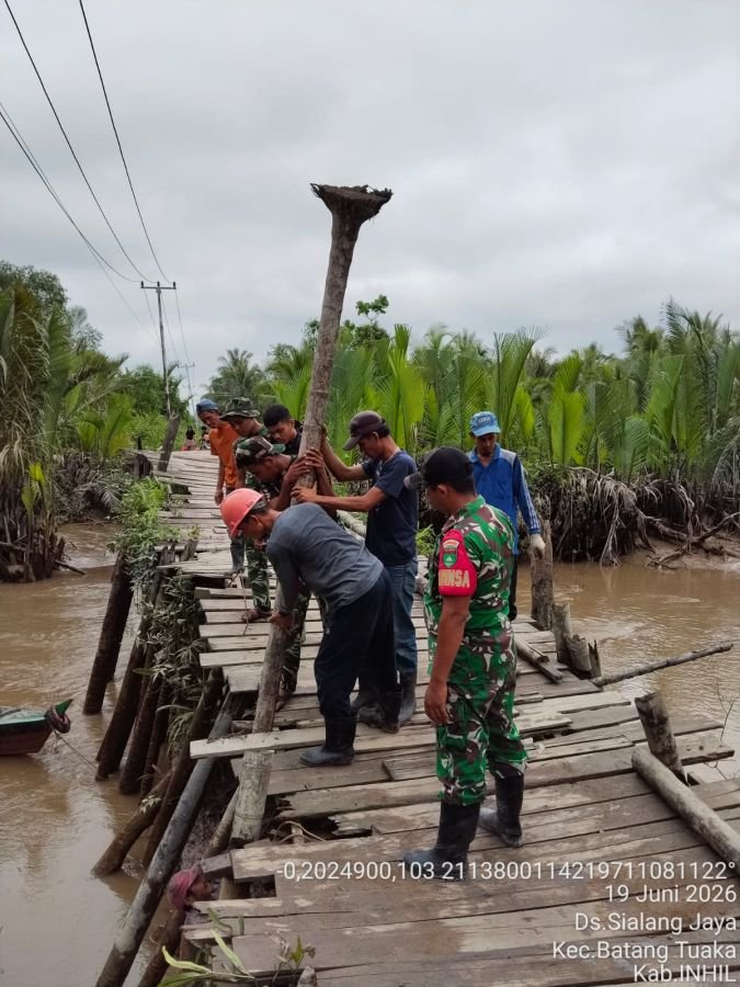 Babinsa Koramil 12/Batang Tuaka Bersama Warga Gotong Royong Perbaiki Jembatan Rusak