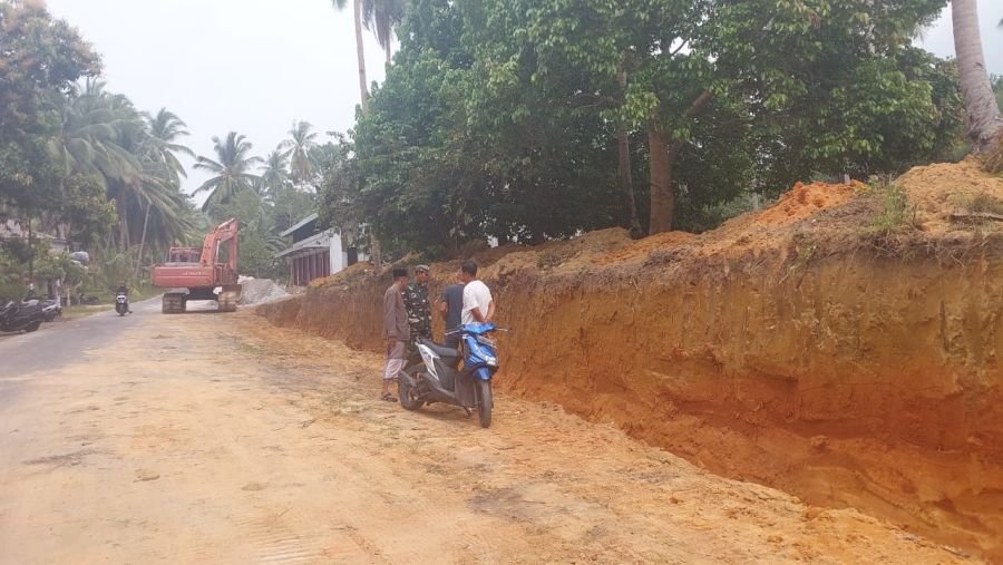 Babinsa Limau Manis Dampingi Pembangunan Batu Miring Antisipasi Longsor