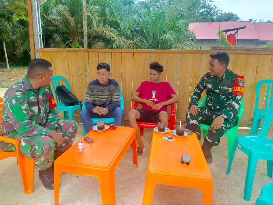 Babinsa melaksanakan komsos bersama masyarakat di sebuah warung kopi