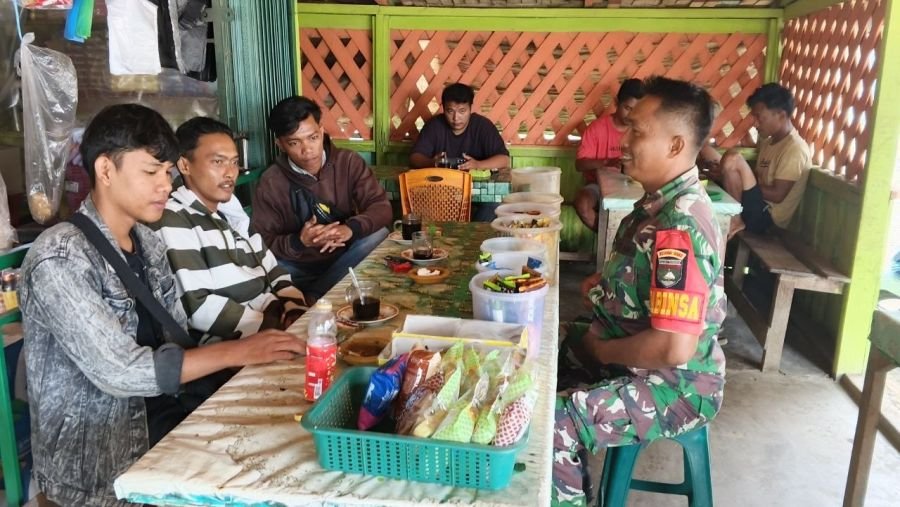 Babinsa melaksanakan komsos di salah satu warung warga
