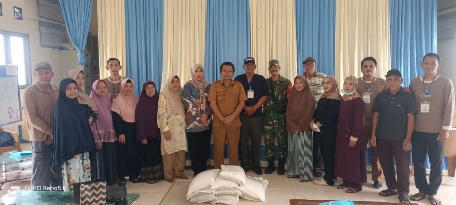 BABINSA MELAKSANAKAN PENDAMPINGAN PEMBAGIAN BERAS BANTUAN KEPADA MASYARAKAT DESA AIR NUSA SEBANYAK 1