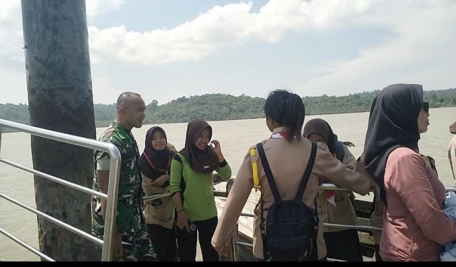 Babinsa Sebele Kawal Keselamatan Pelajar Menyeberang di Tengah Cuaca Buruk