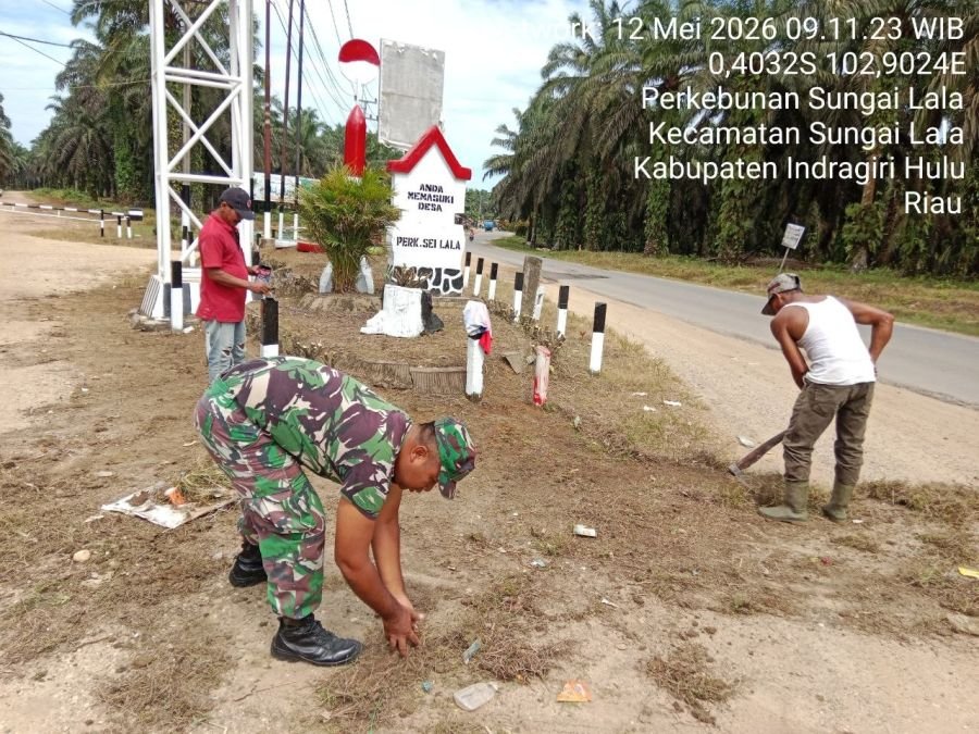 Babinsa Serda Mujiono Bantu Warga Bersihkan Lingkungan di Desa Perkebunan Sungai Lala