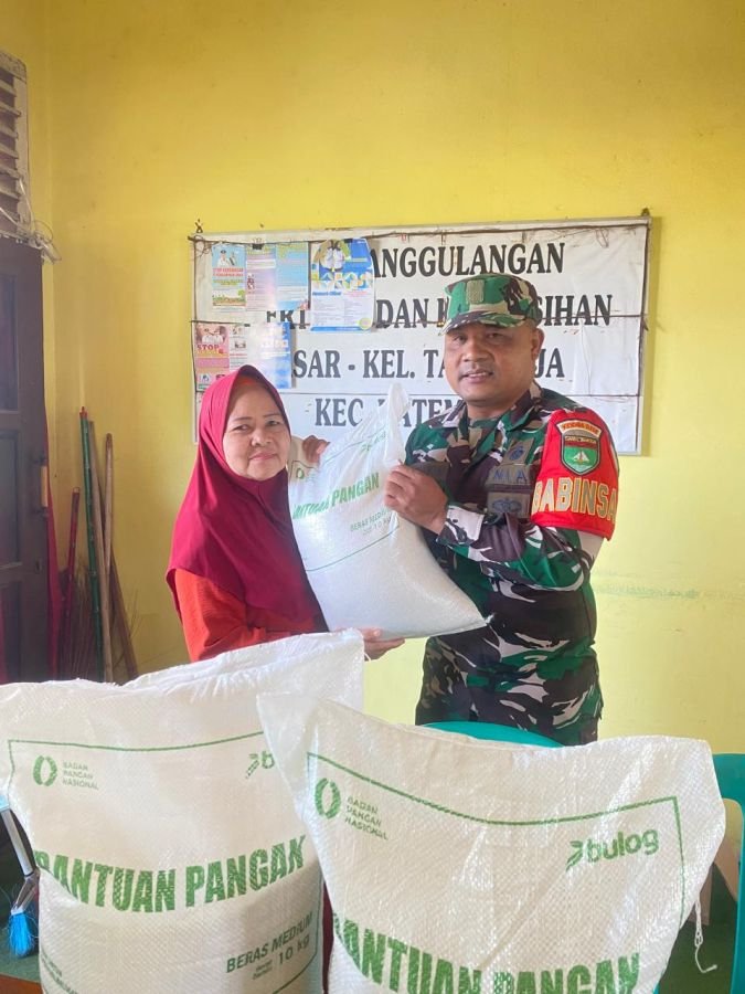 Babinsa tagaraja sertu Edili Z dampingi pembagian sembako berupa beras Bulog untuk masyarakat