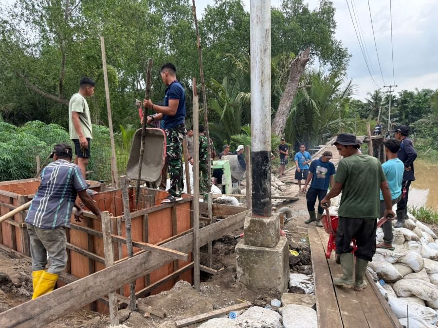 Bahu Membahu, Babinsa Koramil 02/TM Bersama Warga Cor Pondasi Jembatan Perintis Garuda