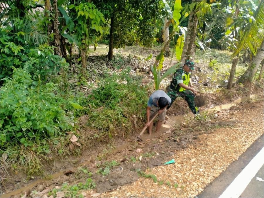 Bati Tuud Koramil 06/Cerenti Bantu Warga Bersihkan Selokan Pinggir Jalan Desa Bedeng Sikuran
