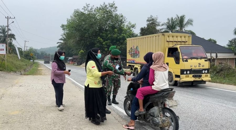 Bersama Tenaga Puskesmas, Babinsa Koramil 09 Singingi Bagikan Masker Cegah Dampak Kabut Asap
