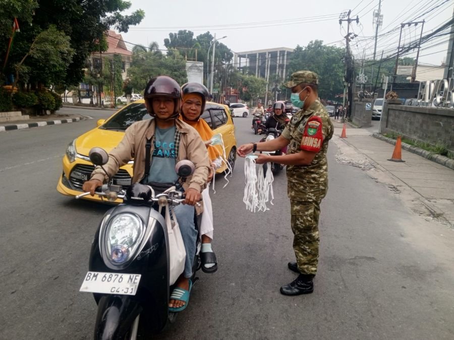 Cegah Dampak Kabut Asap Karhutla, Babinsa dan Camat Sukajadi Bagikan Masker kepada Pengguna Jalan