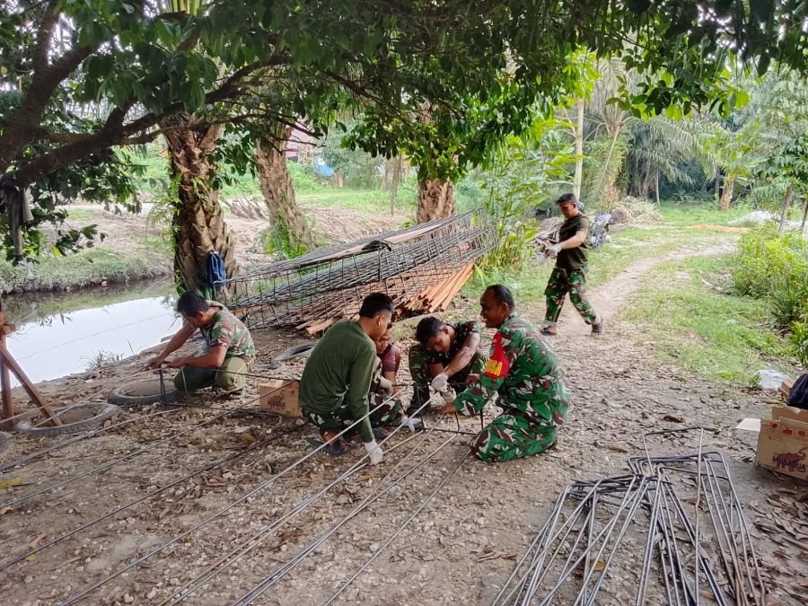 Di bawah Rindang Pohon, Babinsa Sertu Fretriadi dan Warga Rakit Besi Jembatan Garuda