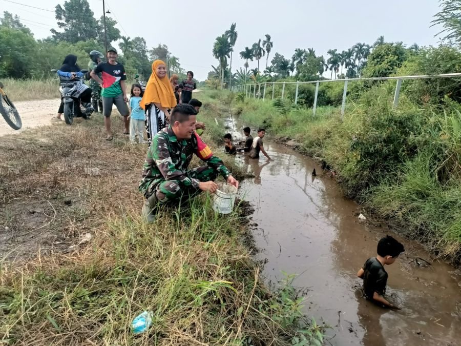 Di Pinggir Parit, Babinsa dan Tawa Anak-anak Menjadi Cerita Sore di Delima