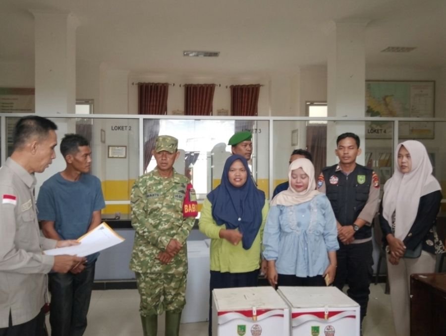 Kawal Pilpeng Serentak 2026, Babinsa Koramil 01/Bangko Dampingi Penyerahan Logistik di Kec.Pekaitan.