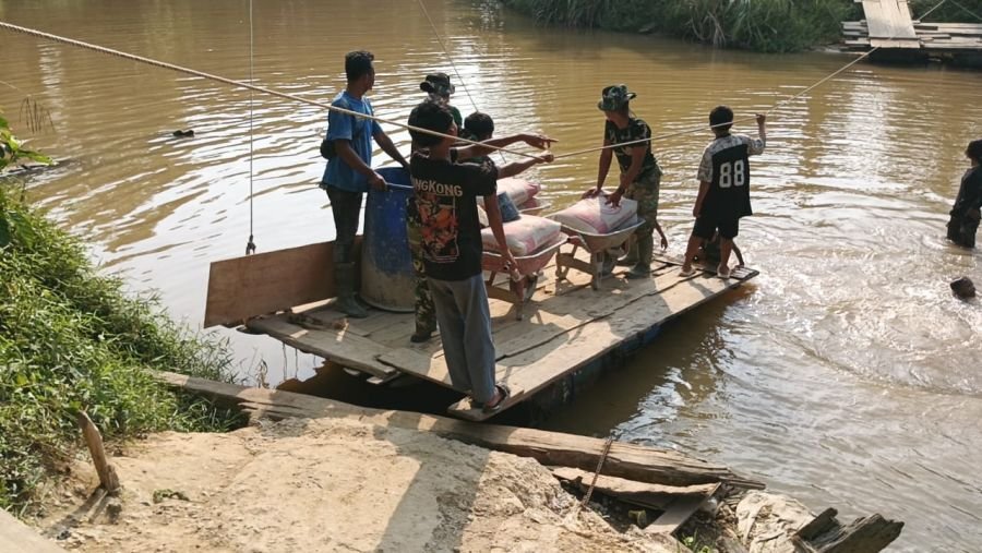 Kebut Pembangunan, Babinsa Kemuning Angkut Material Menuju Tepi Jauh Jembatan Perintis Garuda