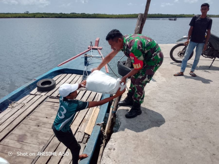 Kegiatan Komsos Babinsa Koramil 06/Serasan Membantu Warga Menurunkan Barang ke Kapal