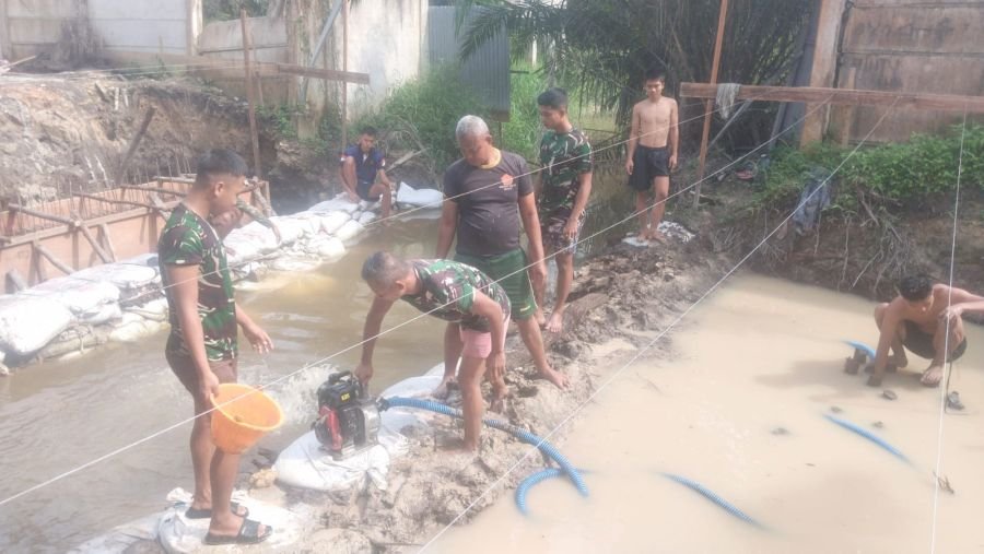 Personel Kodim 0301/Pekanbaru Bersama Warga Atasi Genangan di Area Pengecoran Jembatan