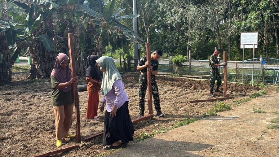 Prajurit Kompi Senapan B Yonif TP 850/SC menggelar aksi gotong royong bersama Kelompok Wanita Tani