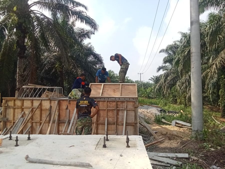 Semangat Kebersamaan: Babinsa 09/Kemuning Lanjutkan Pengecoran Pondasi Atas Jembatan Garuda