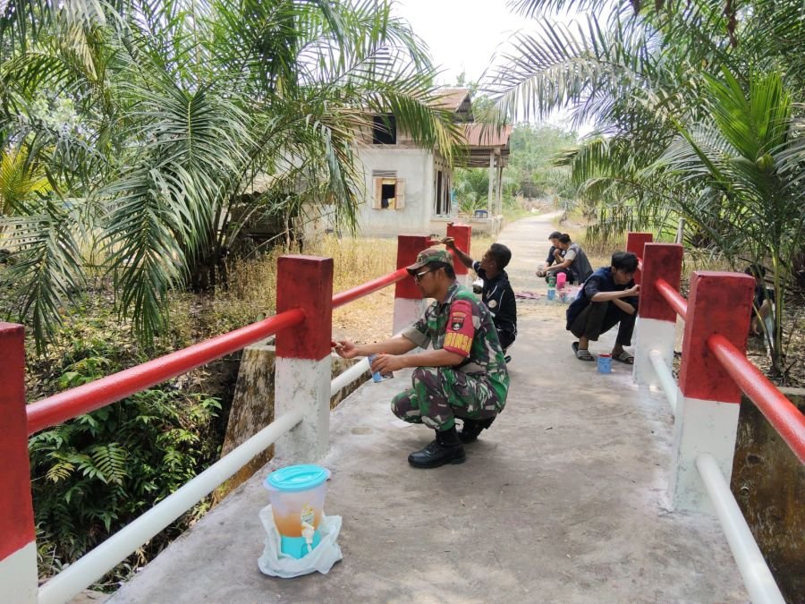 Semangat Merah Putih Menggelora! Babinsa, Pemuda dan Mahasiswa KKN Kompak Percantik Jembatan Okura