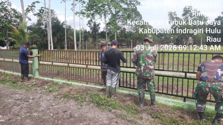 Wujud Kemanunggalan TNI-Rakyat, Babinsa Bantu Warga Cat Pagar Pustu Desa Rimpian