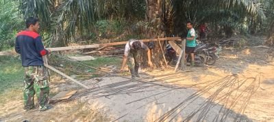 Babinsa 09/Kemuning Bersama Warga Lanjutkan Pemotongan Besi Tulang Angkur Jembatan Perintis Garuda