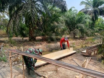 Babinsa Koramil 01/Rengat dan Warga Gotong Royong Percepat Pembangunan Jembatan Garuda