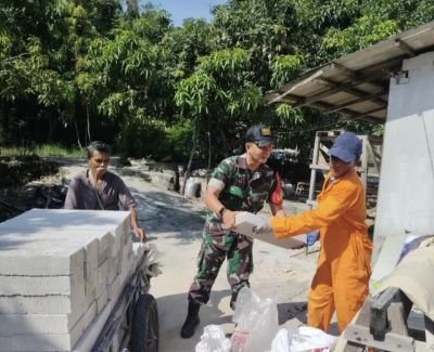Babinsa Tanjung Sari Bantu Warga Turunkan Material Bangunan